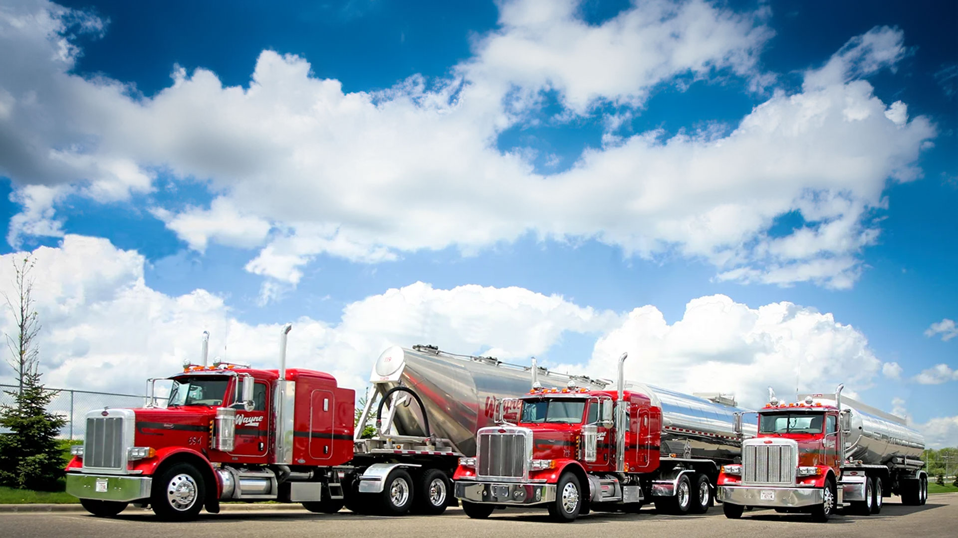 Red semi truck of the 10-65 Logistics shipping and transportation fleet drives nationwide and regional route in the rain