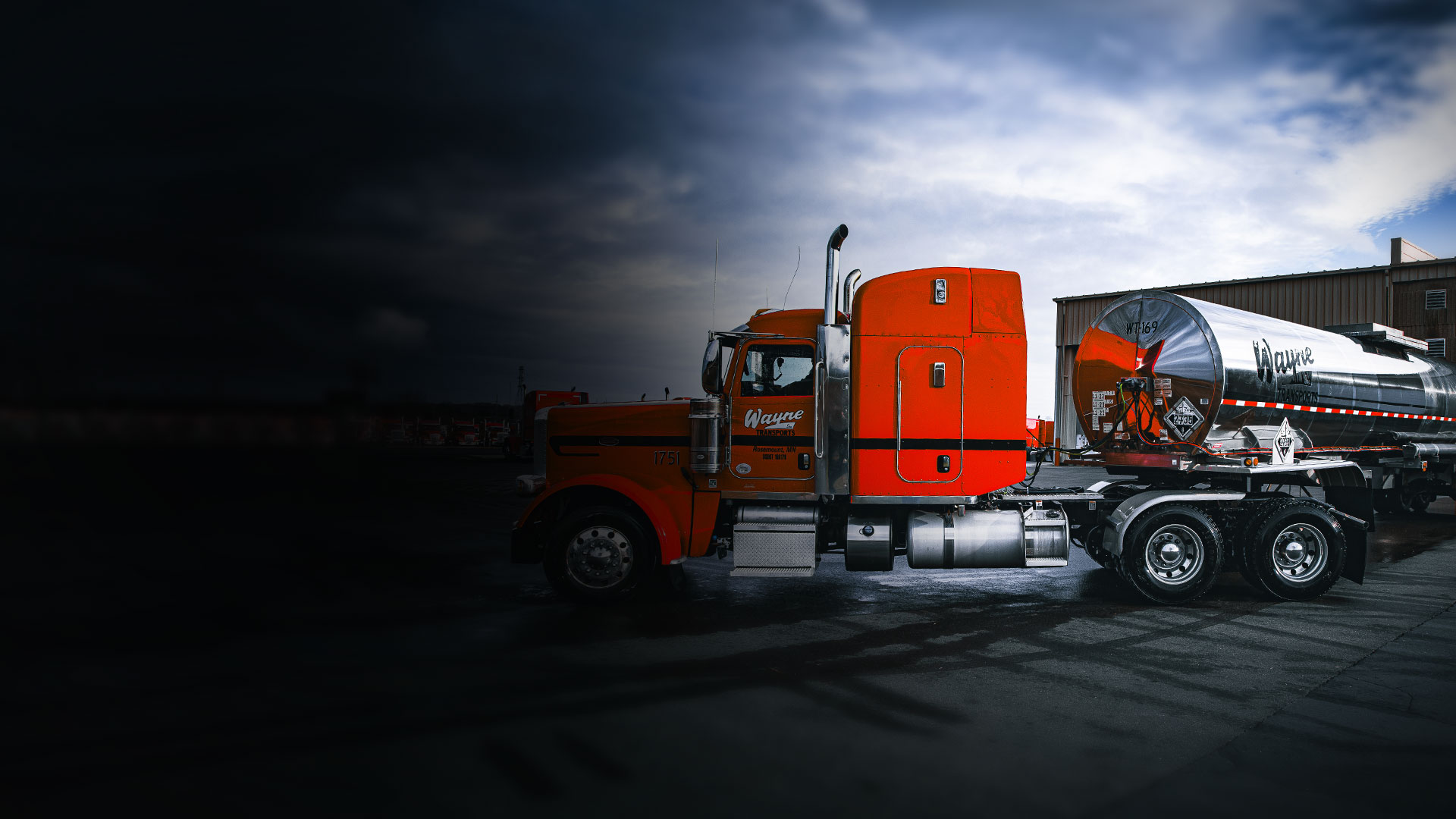 Red semi truck of the 10-65 Logistics shipping and transportation fleet drives nationwide and regional route in the rain