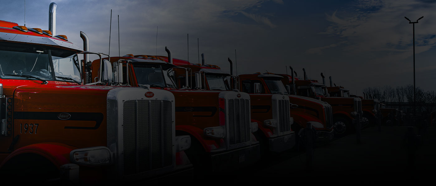 Red semi truck of the 10-65 Logistics shipping and transportation fleet drives nationwide and regional route in the rain